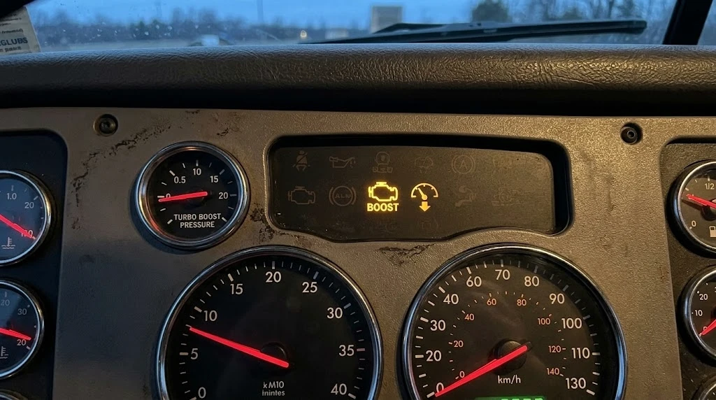 Semi truck dashboard showing engine warning light and high EGT reading — symptoms of a failing charge air cooler